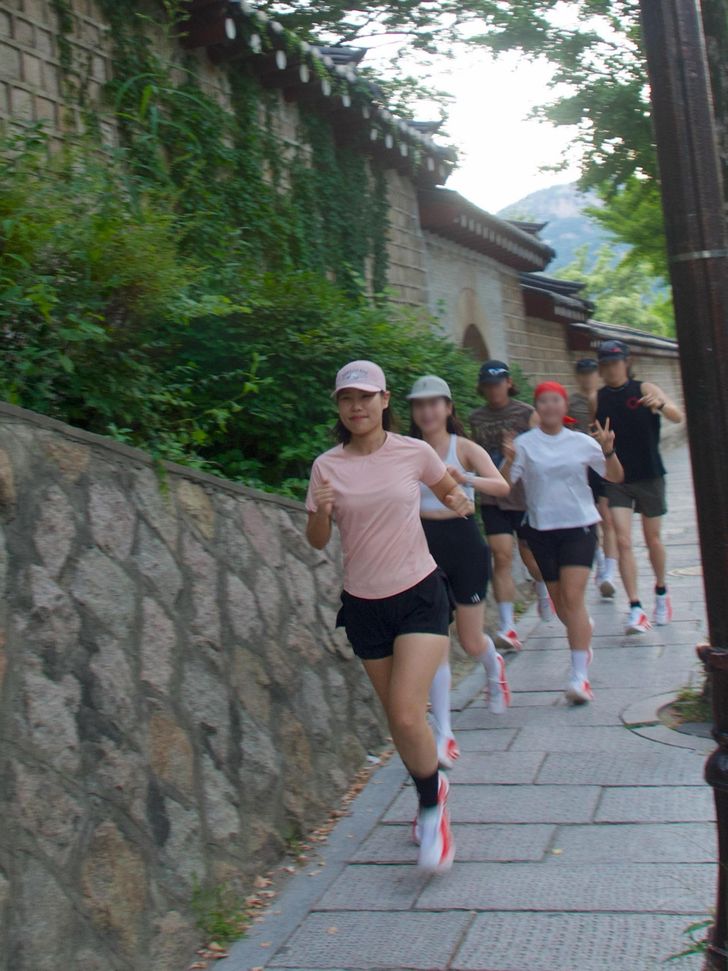 Park Eun-kyung, front, and other runners on a run circling Gyeongbok Palace in central Seoul, Aug. 13. Captured from Instagram (@runlife_ek)