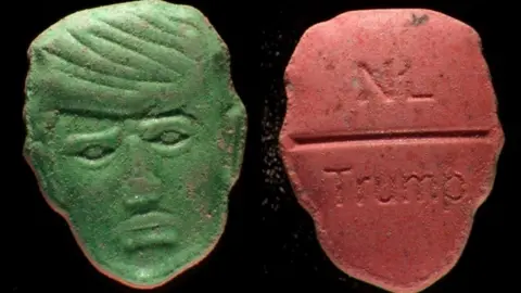 Trimbos Institute Front and back picture of an ecstasy pill in the shape of US President Donald Trump's head. The green front is a depiction of Trump's face carved into the pill; the back, in red, features the word "NL" carved at the top of a break line under which is stamped the word "Trump"