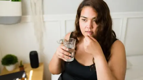 Getty Images Woman taking pill