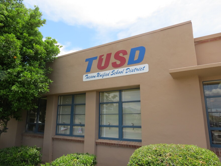 Brown stucco building with red, blue and white sign reading TUSD Tucson Unified School District