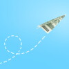 Dollar paper airplane flying against blue background, business concept