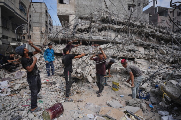 Palestinians remove iron from the rubble of buildings destroyed by Israeli airstrikes during the war with Hamas, repair and recycle it for construction, building tents or selling it, in Gaza City, Sunday, Aug. 16, 2026. (AP Photo/Jehad Alshrafi)