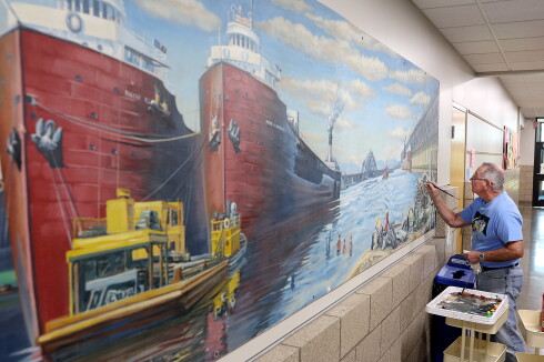 Former teacher restores an old mural.