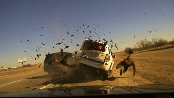 In this screen grab taken from dash camera video provided by the Oklahoma Highway Patrol, Trooper Jesse Gregory is struck by a motorist while talking to the driver of a parked vehicle on the side of Interstate 40 near the Oklahoma City suburb of Yukon, Thursday, Jan. 18, 2024. (Oklahoma Highway Patrol via AP)