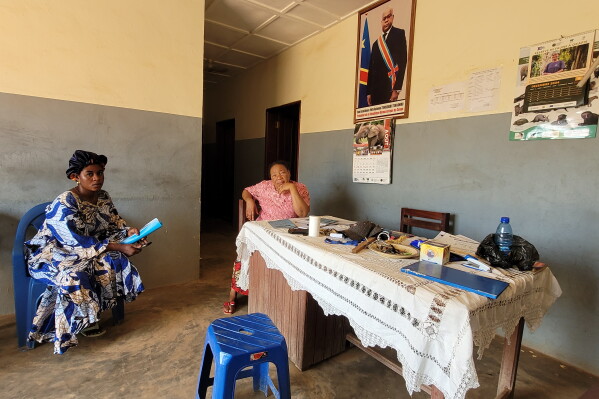 Parents who came for their children's school resumption sit inside an office of a school in Ituri province, eastern Congo, Thursday, Aug. 27, 2026. (AP Photo/Constant Same Bagalwa)