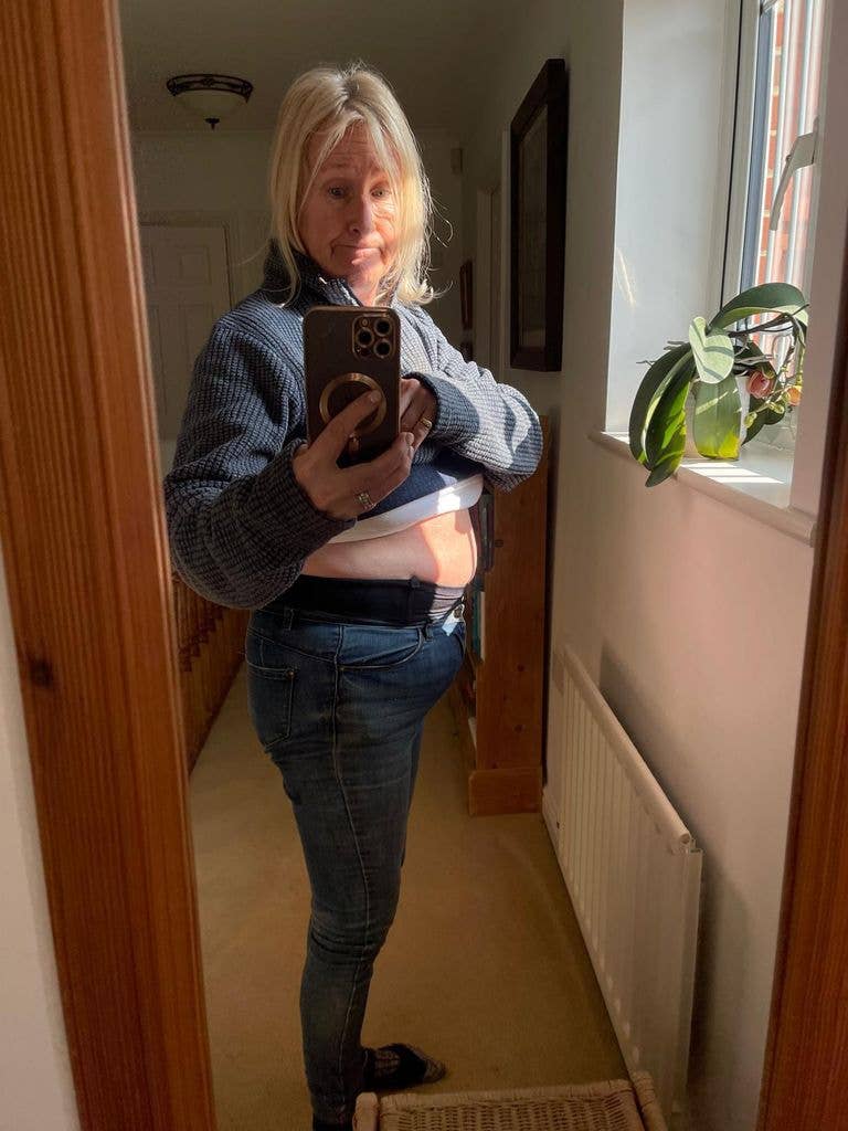 Emma posing in mirror with tummy out