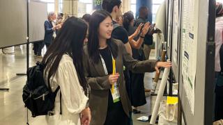 Yue Zhan looks at a poster with another conference goer
