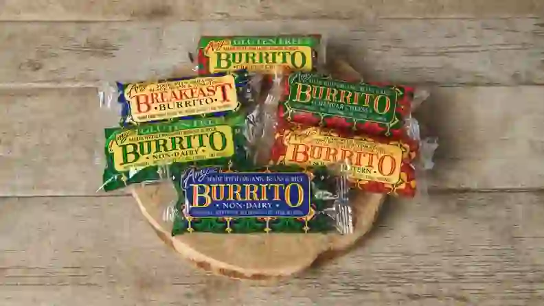Assortment of Amy's Kitchen frozen burrito packages on a wood board