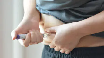 A person injects their abdomen with a weight-loss injection