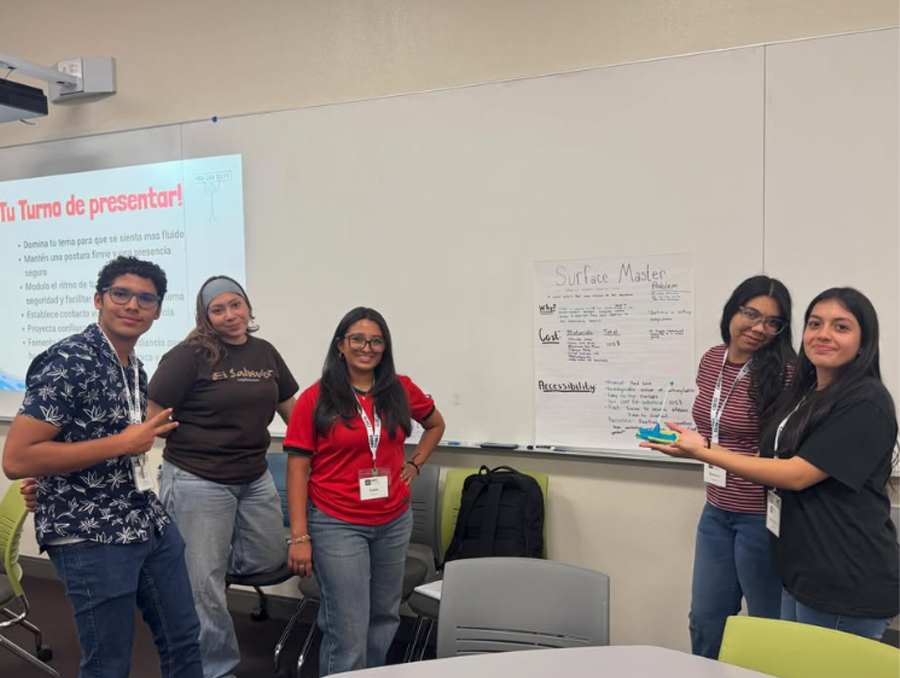 A group of students present a poster in a classroom