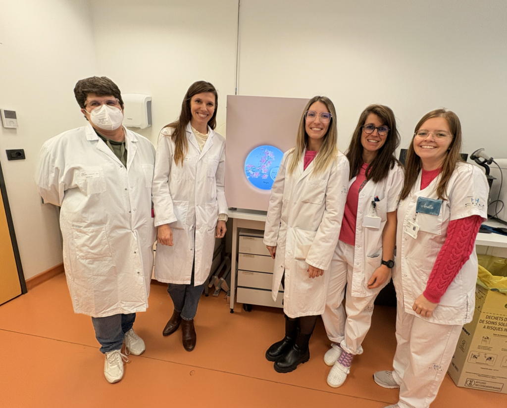 The Molecular Genetics Unit team at CHU Nîmes standing beside the PacBio Vega system in their laboratory.