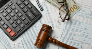calculator, documents, cash, glasses and a gavel on a table by Depositphotos
