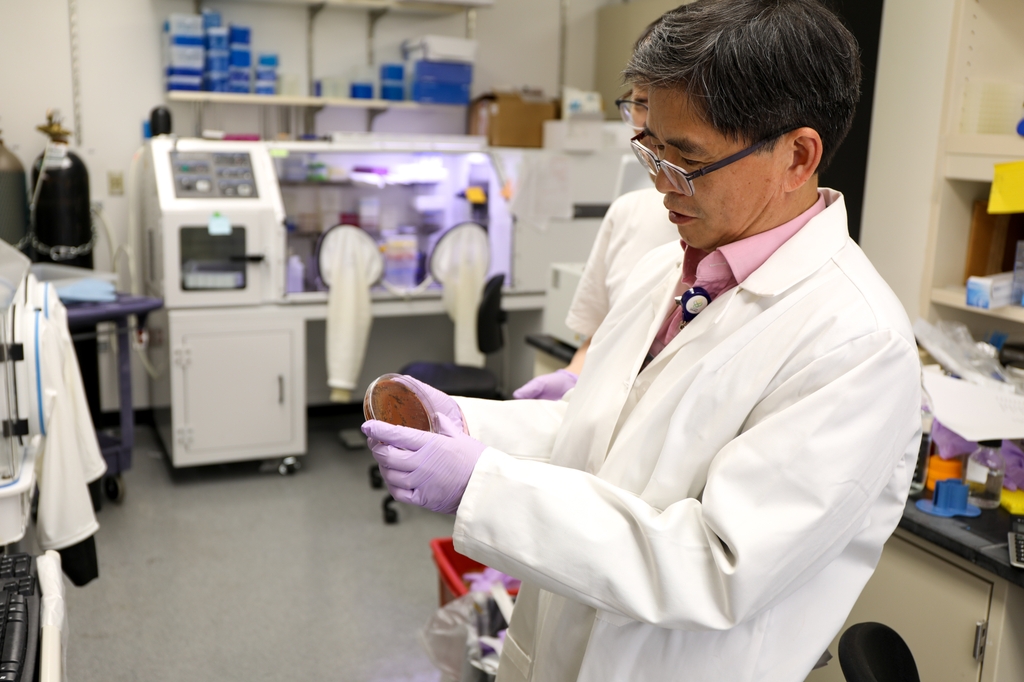 Wu holds a dish of bacteria in his lab.
