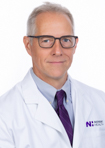 Dr. Neil McDevvit wears a white coat and smiles.