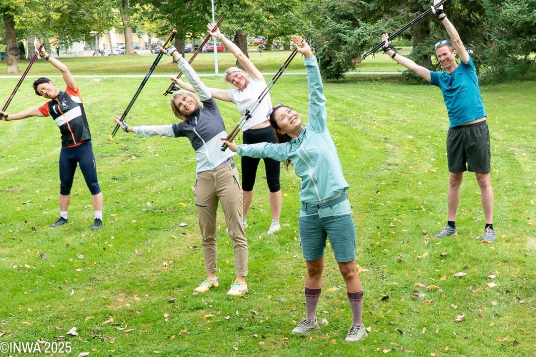 Members of a Nordic walking class using the poles to stretch and improve mobility (International Nordic Walking Federation)