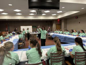 Trista Sneed, director of the MASH Camp at Conway Regional, instructs students on their suturing tools.