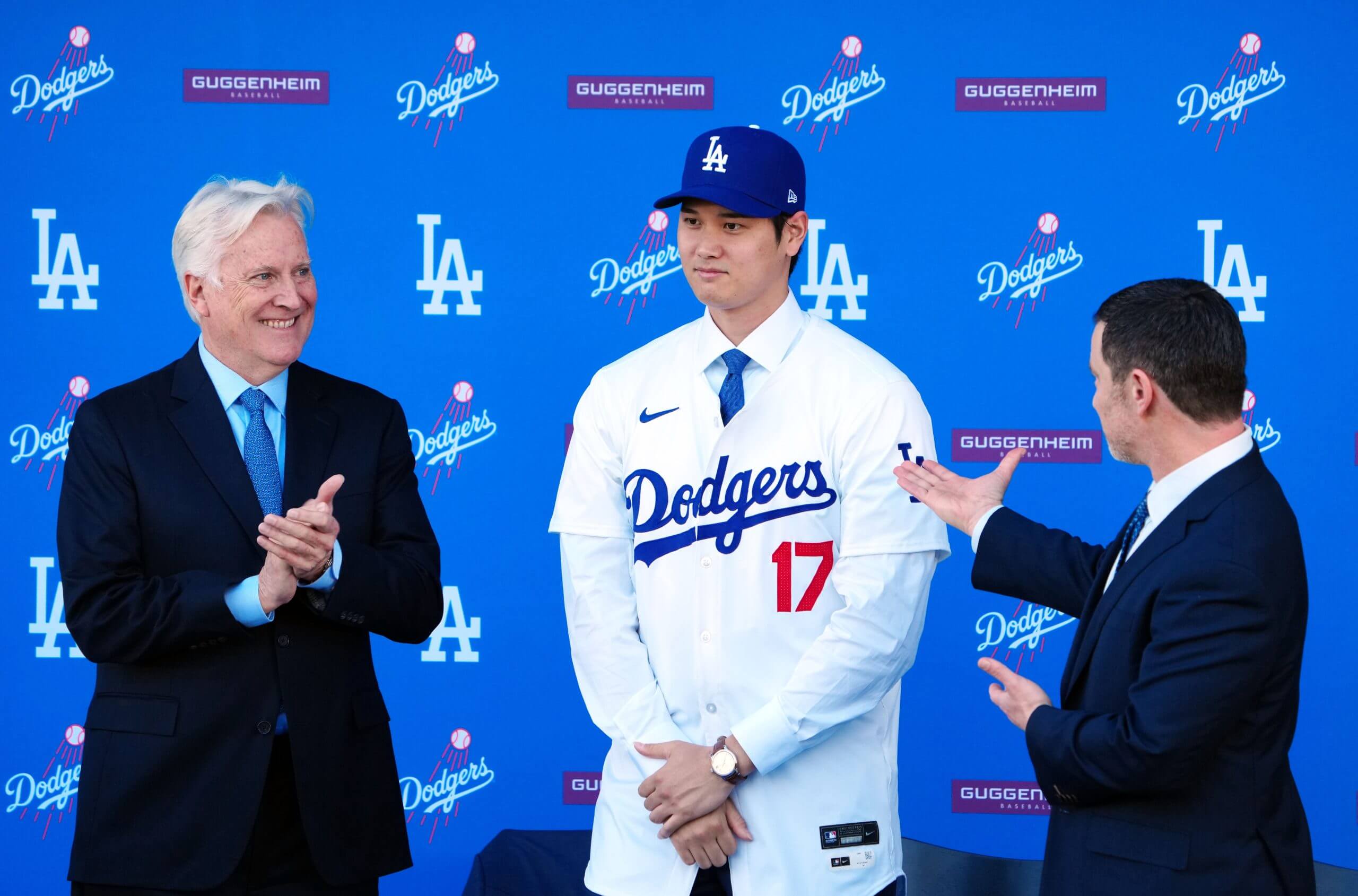 Los Angeles Dodgers owner Mark Walter (left) and president of baseball operations Andrew Friedman (right) introduce Shohei Ohtani at an introductory press conference at Dodger Stadium. Mandatory Credit: