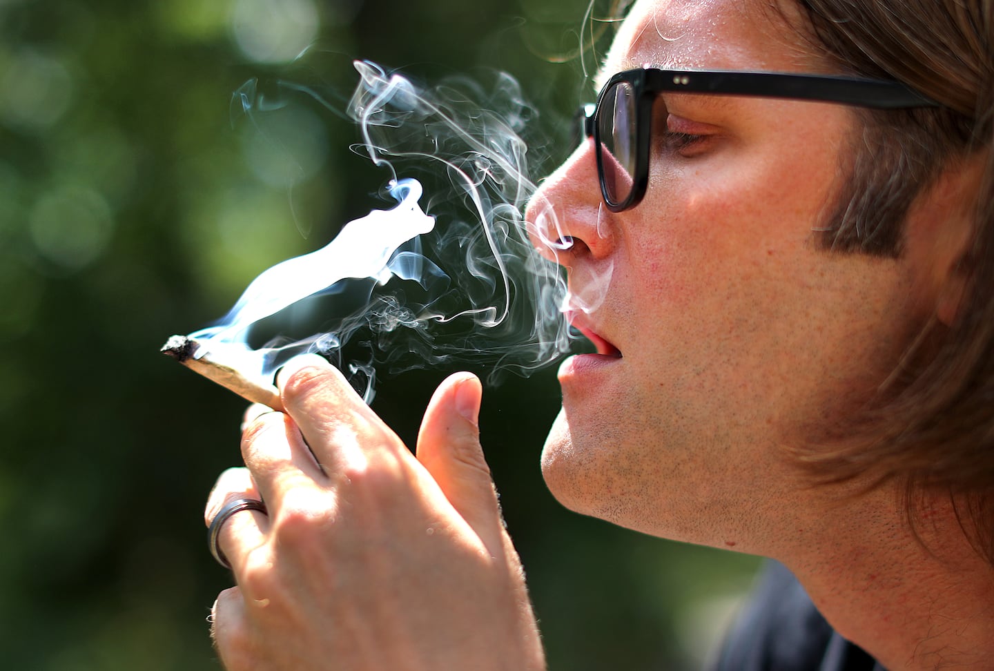 Joshua DeLillo enjoys a smoke at a park near his home.  John Tlumacki/Boston Globe