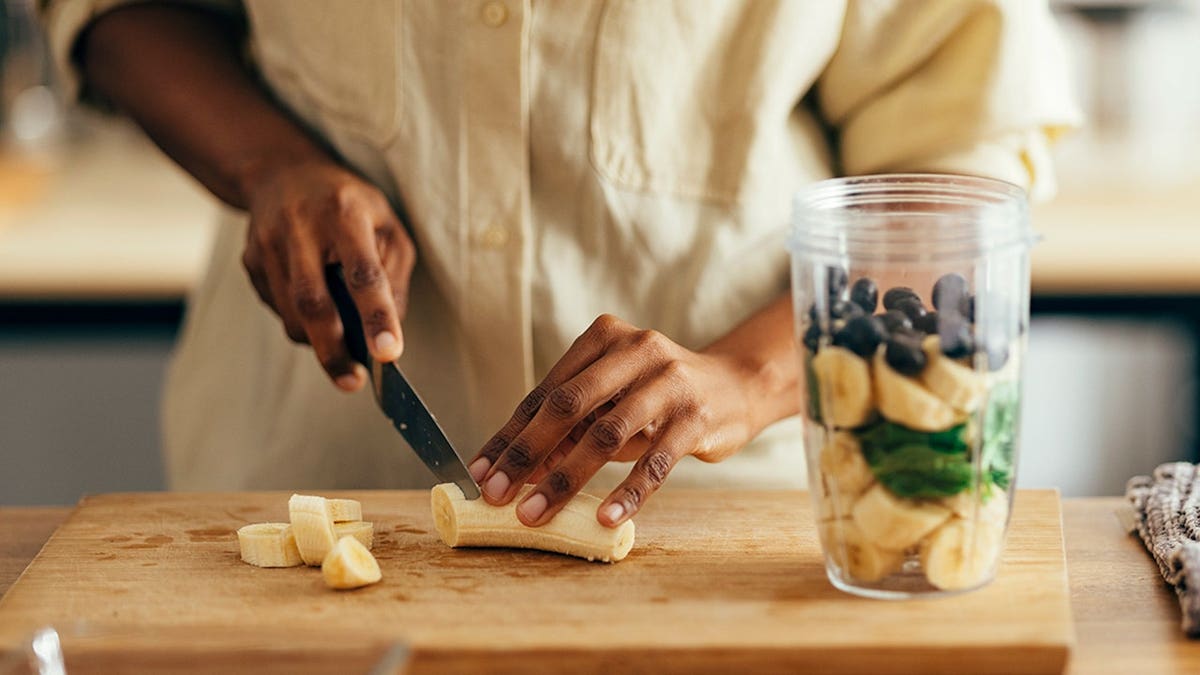 Woman prepares a healthy breakfast at a kitchen table.