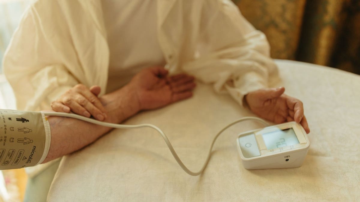 A person using a blood pressure cuff