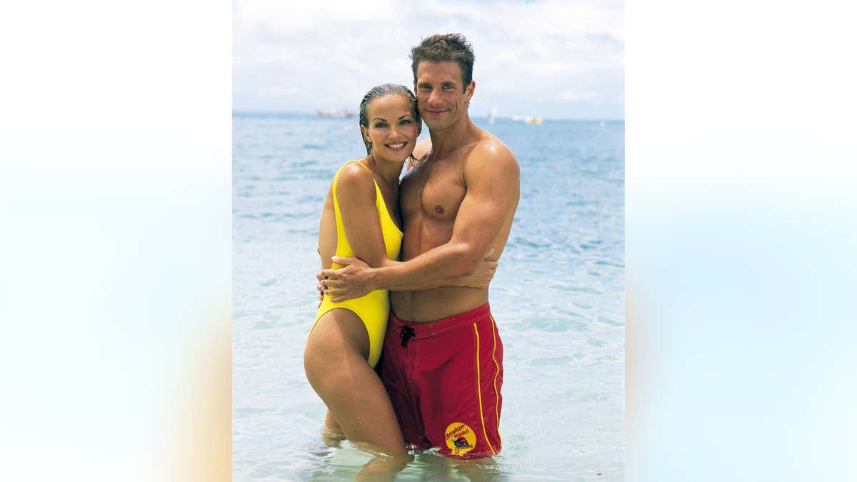 Actors Brandy Ledford and Jason Brooks pose together for a photo.