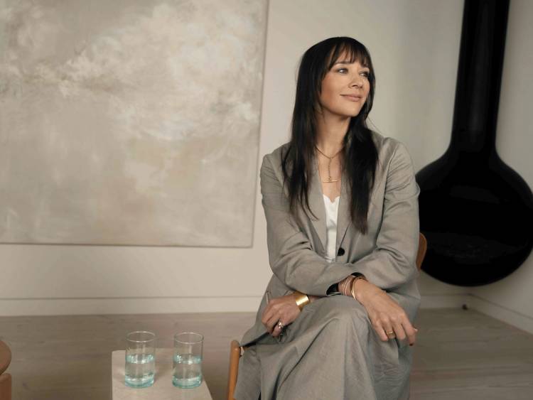 Rashida Jones sits in a gray suit during a portrait session for Hårklinikken.
