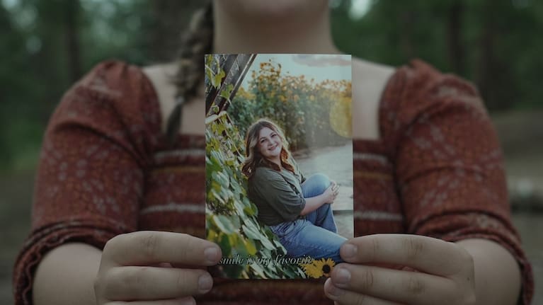 Charlotte Touzalin holds a photo of herself.