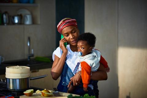 Mother holding toddler in a kitchen