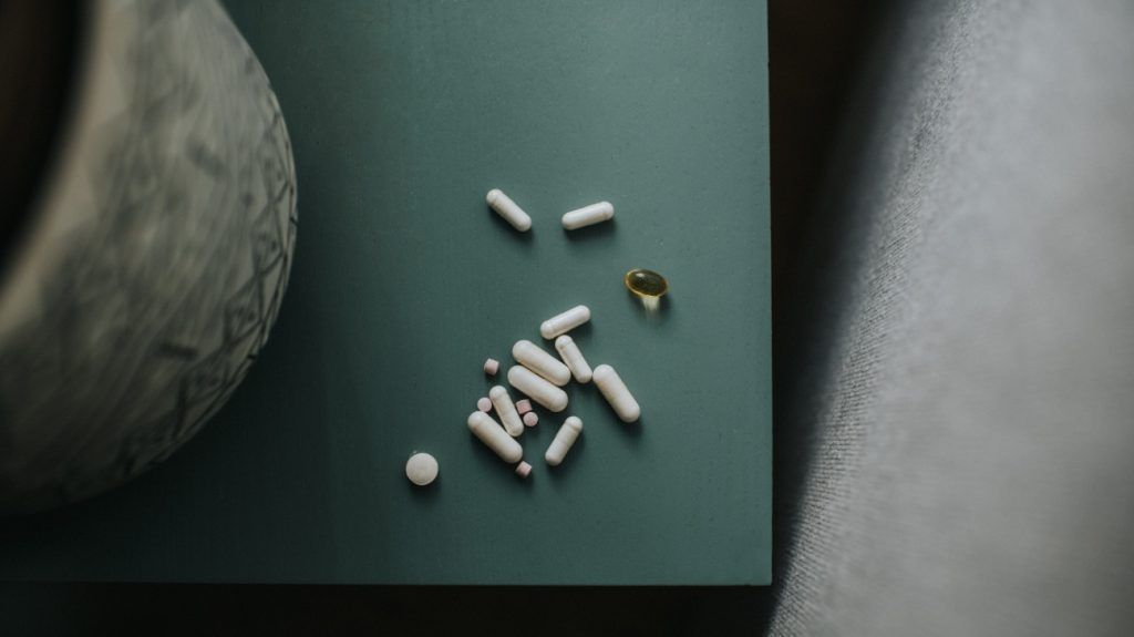 close-up of supplement capsules on green surface