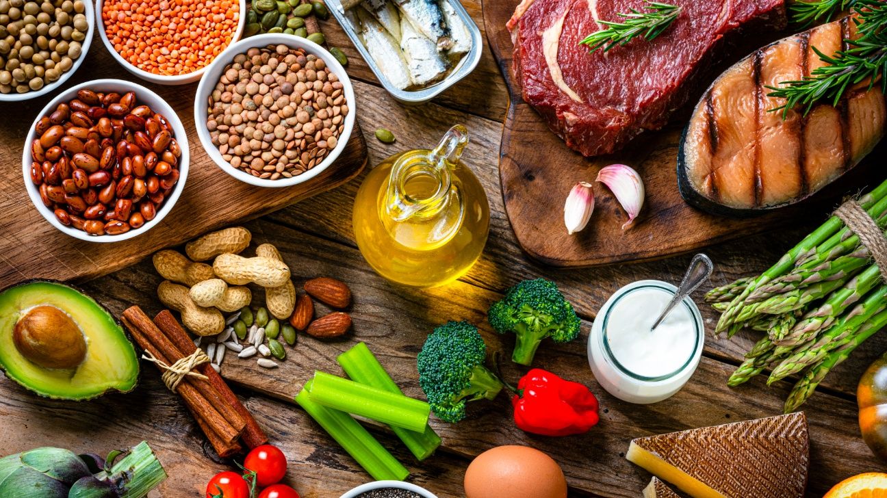 Vegetables, lean meats, and legumes on wooden chopping boards