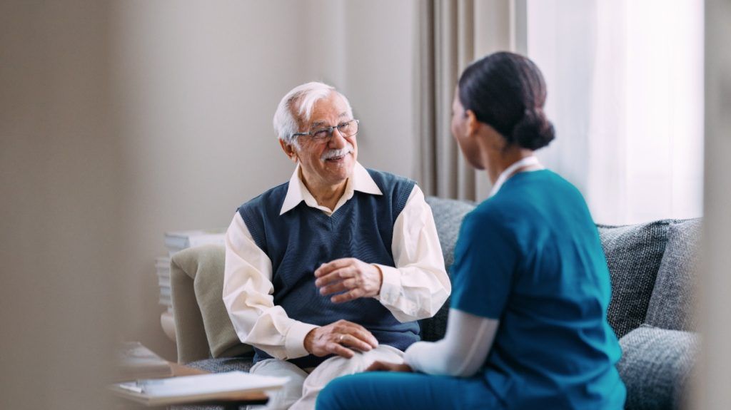 An older adult is talking with a medical professional.