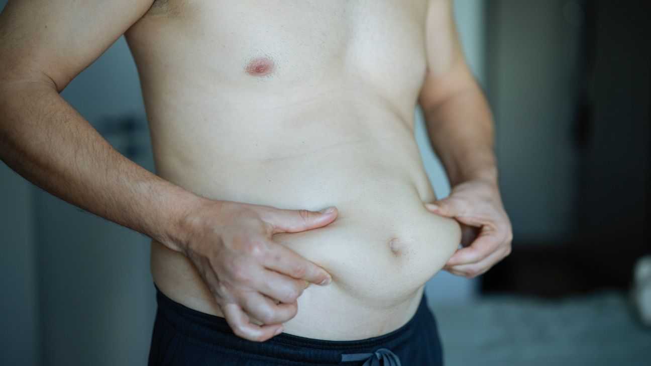 Male holding his belly fat in his hands