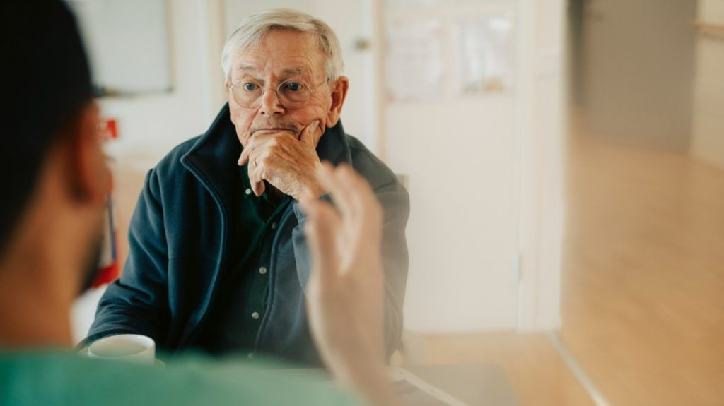 An older adult male has a conversation with a male doctor about Alzheimer-s blood-based biomarker tests