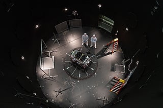 FILE - This photo provided by NASA shows Kieran Wilson, LINK's principal investigator, and Hunter Robertson, a space systems engineer, both at Katalyst Space, standing next to their spacecraft inside the SES (Space Environment Simulator) at NASA's Goddard Space Flight Center in Greenbelt, Md., April 17, 2026, ahead of thermal vacuum testing.