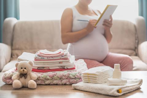 Pregnant woman at home, reviewing her hospital bag checklist