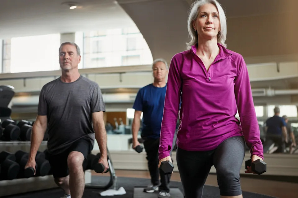 Adults performing functional strength exercises in a gym, highlighting mobility and balance as people age.