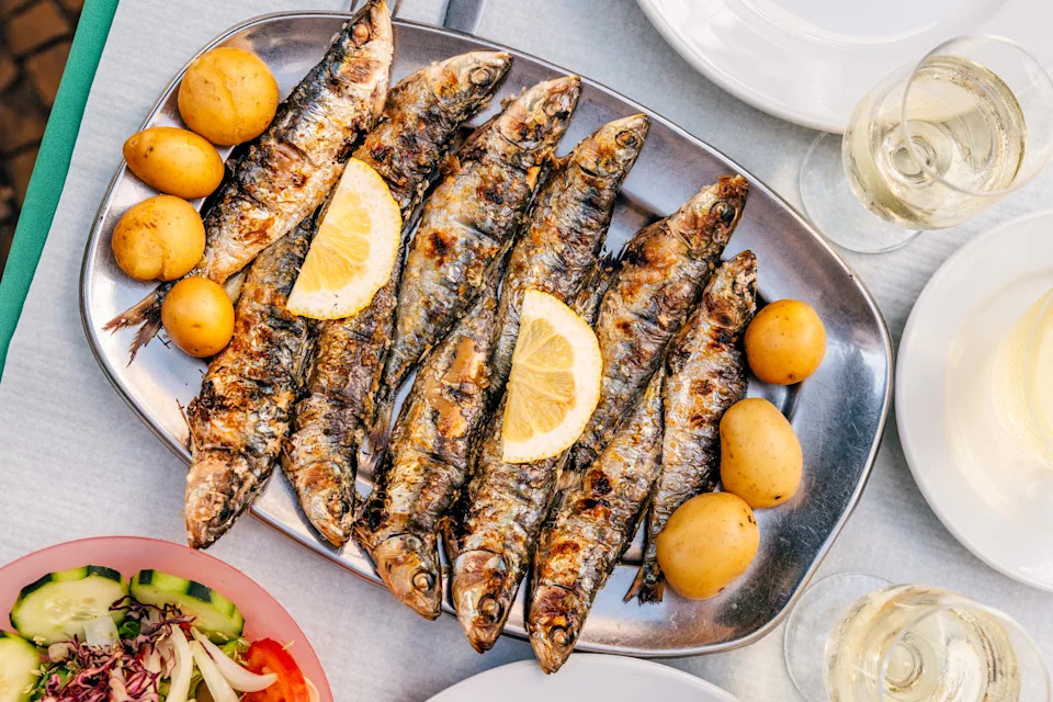 Portuguese food - Grilled sardines with potatoes served at a restaurant, high angle close-up view