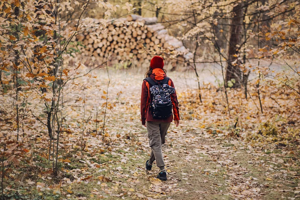 A woman walks outdoors in fall