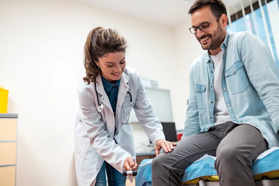 Orthopedic doctor examining a patient's knee, where every pound of excess weight adds four pounds of joint force