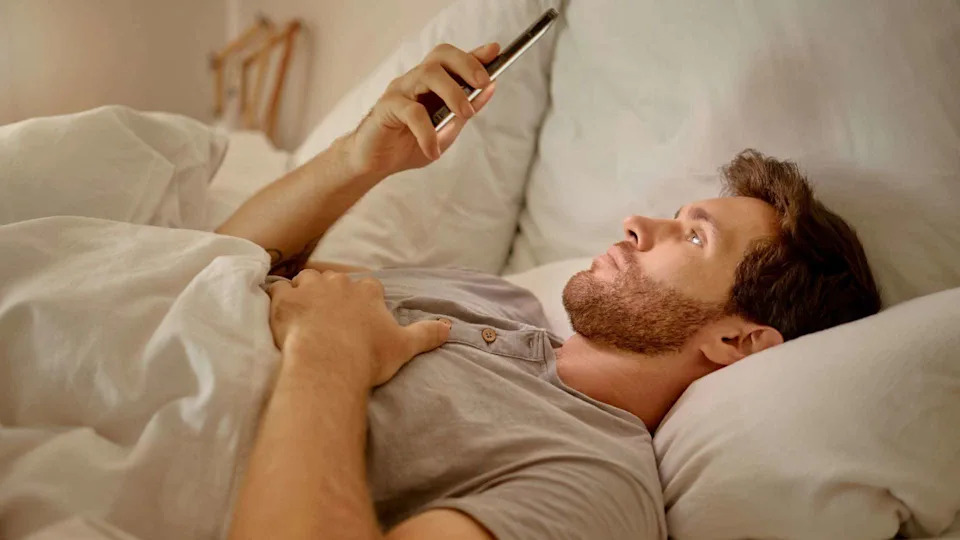 Man using a phone in bed