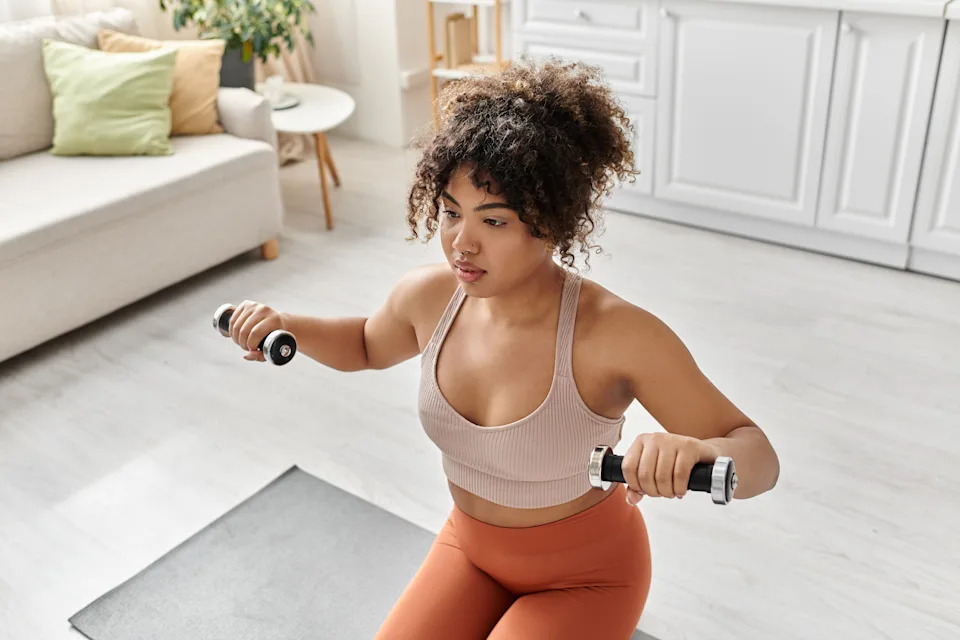 Woman lifting dumbbells during a home strength workout supporting brain and mood benefits