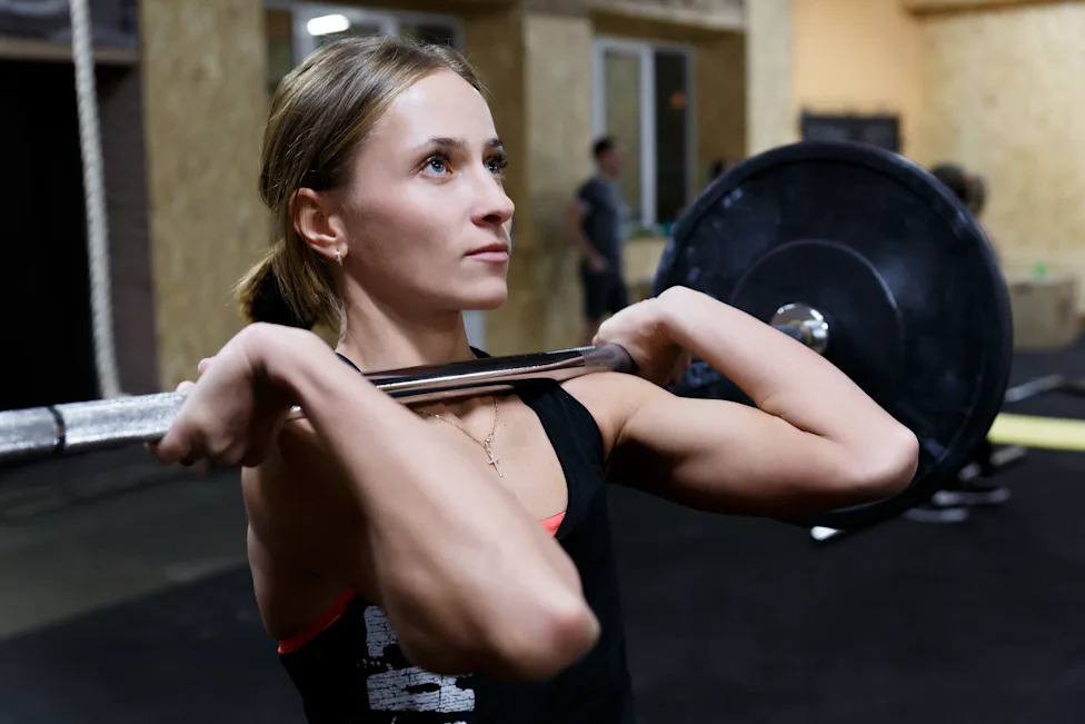 Woman lifting a barbell during a strength training workout, reflecting the shift toward functional fitness and longevity in 2026.