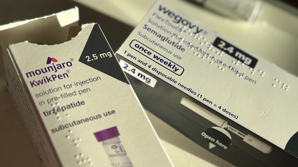 Two boxes containing pre-filled injection pens. On the left a white card box with purple writing is labelled as containing a Mounjaro Kwikpen marked for "subcutaneous use". On the right of the picture is another white box with black detailing labelled as Wegovy states it's a pre-filled pen containing Semaglutide.