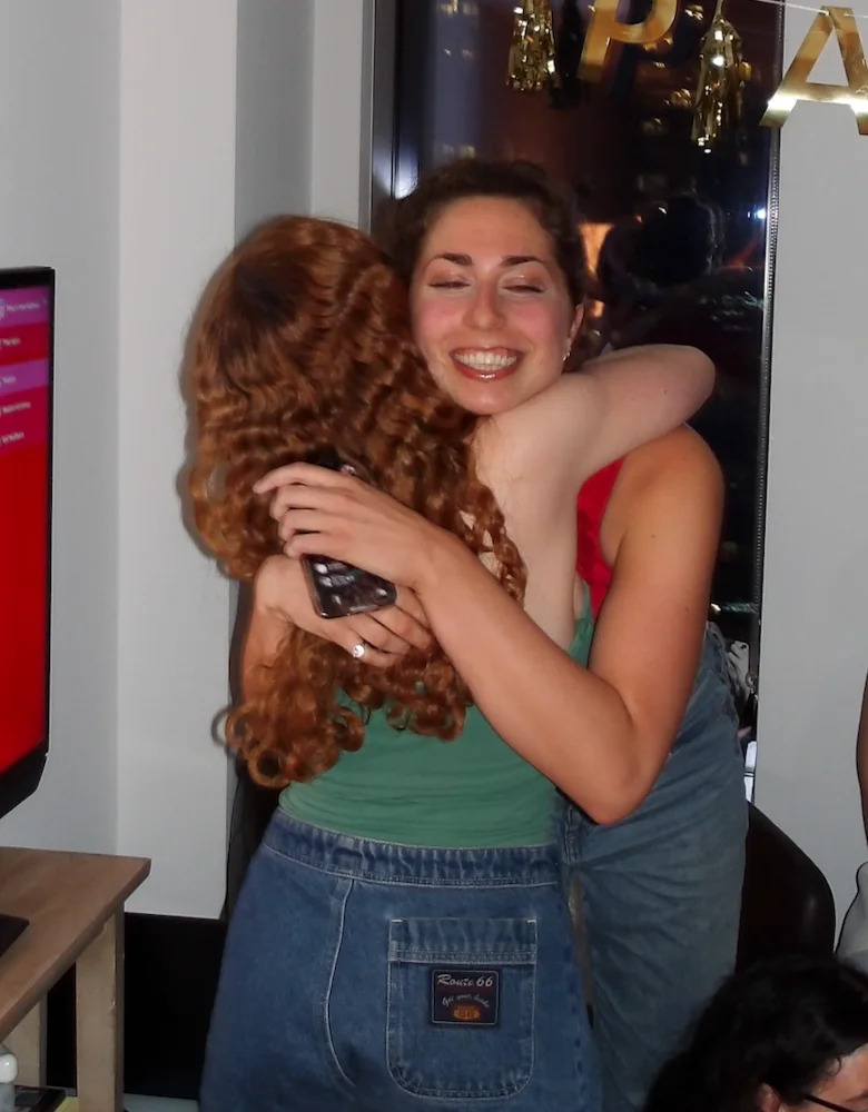 Two people joyfully embrace indoors, conveying warmth and affection