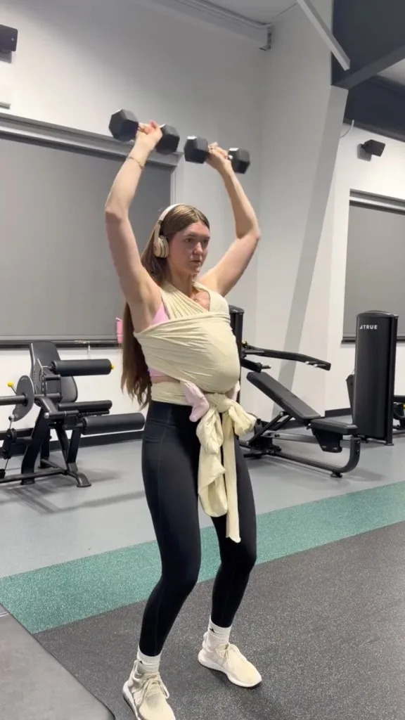 Influencer Angela Holm is catching virtual heat for bringing her newborn baby to the gym at night, and working out with the kiddo strapped to her chest.  TikTok/@angela.holm