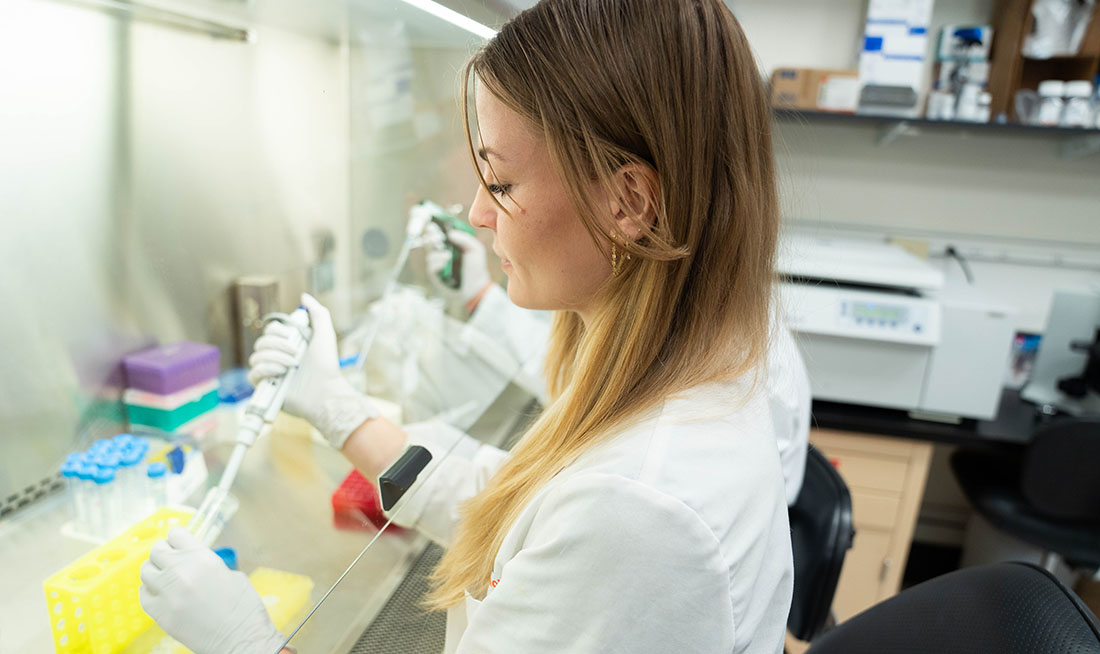 Marlene Redlich works in a laboratory at the University of Miami Miller School of Medicine, using a pipette inside a biosafety cabinet as part of her diabetes research.