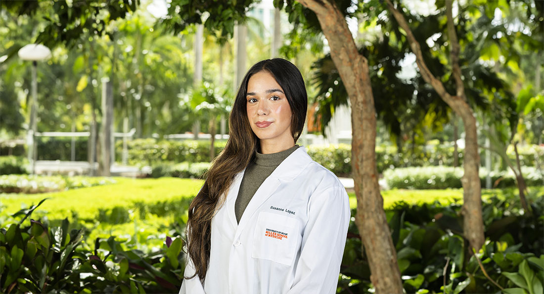 Susanne Lopez, a NEXCITE participant, wears a white University of Miami Miller School of Medicine lab coat outdoors.