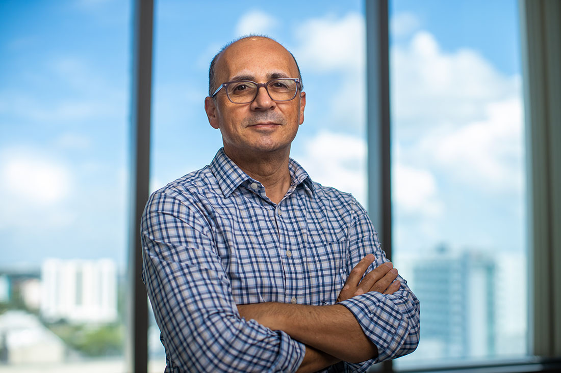 Dr. Michael Benatar, standing with his arms crossed in front of a window