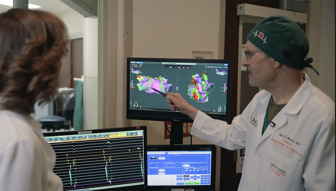 Dr. Raul Mitrani reviews detailed 3D cardiac mapping images and heart rhythm data on multiple monitors during an atrial fibrillation evaluation.