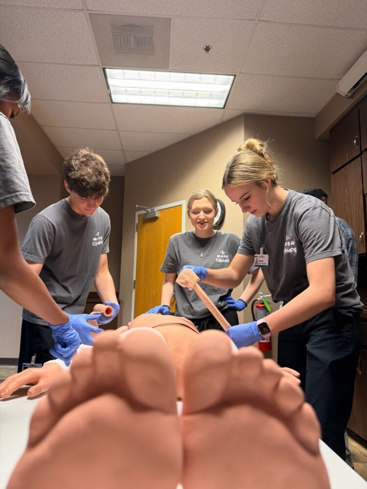 Students wrap a manikin at Malvern's MASH Camp.